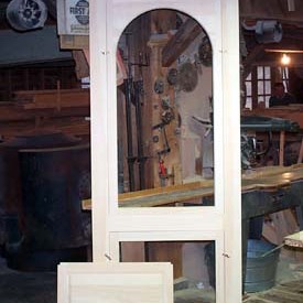 An unusual combination door. Both screen and glass upper inserts have a round top and the lower panel insert has a solid wood raised panel for winter which is replaced by a screen in the summer giving you maximum ventilation. The extra long stiles you see on all our doors act as feet. These feet protect the corners of the door between the day it is assembled and the day you hang the door, assuring that you to have sharp corners.